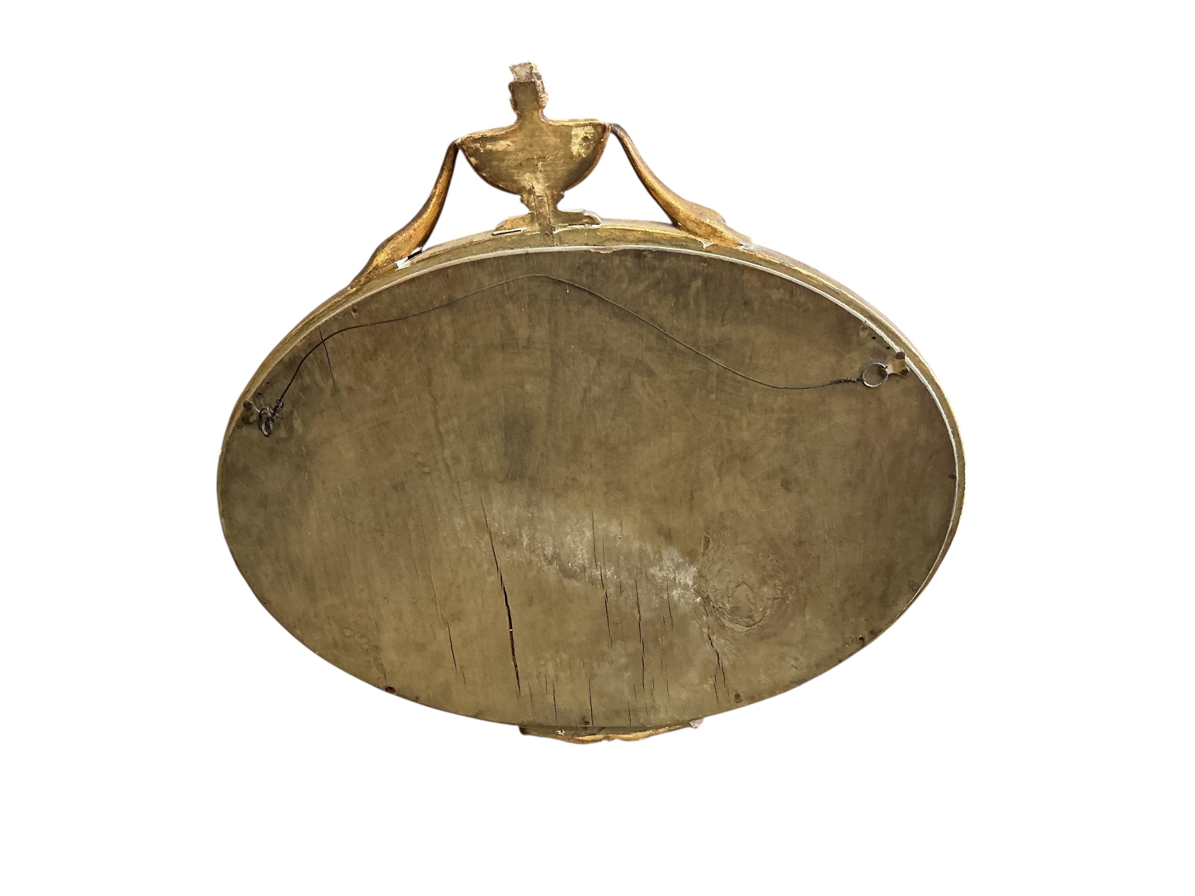 An Sheraton style oval gilt framed wall mirror, width 65cm, height 63cm